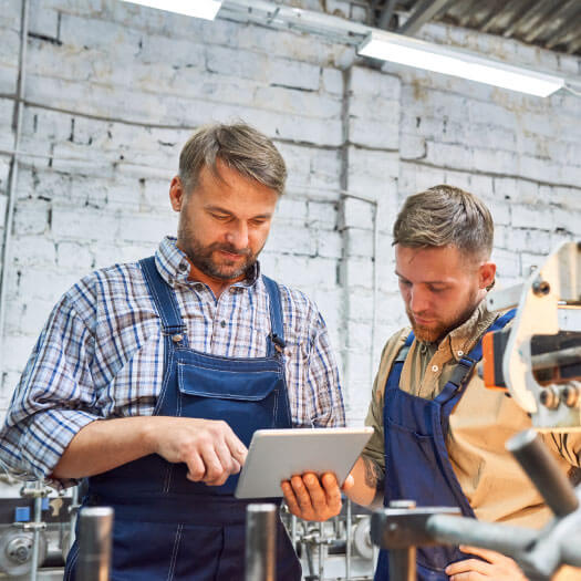 Workers using manufacturing travelers software